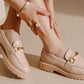 Beige loafers worn by a person on a beige background