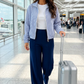 Woman in an airport pulling a suitcase