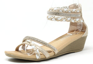 A gold-colored wedge sandal with triple ankle straps and a rhinestone-embellished strap across the foot. The sandal features a open toe design and a comfort sole.
