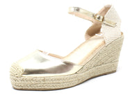 Gold wedge sandal with espadrille sole on a white background