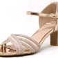 A champagne shimmer ribbon heel with crossover toe traps, an adjustable ankle strap, and a slim heel.