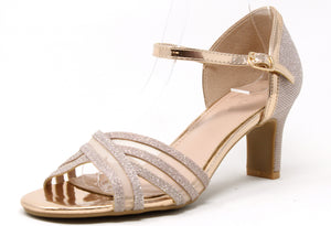 A champagne shimmer ribbon heel with crossover toe traps, an adjustable ankle strap, and a slim heel.
