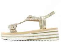 Gold sandal with platform sole on a white background