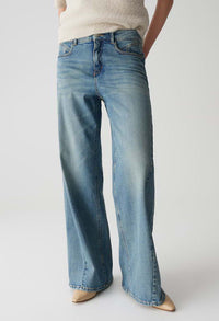 Person wearing light blue jeans on a plain background
