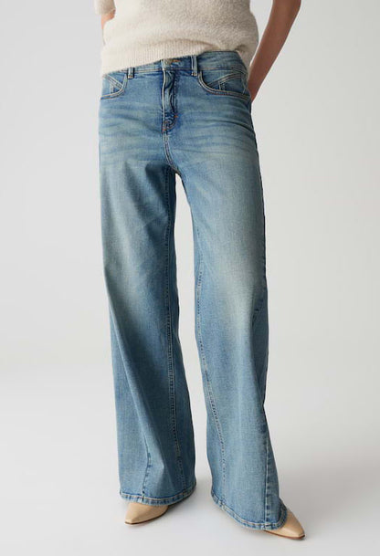 Person wearing light blue jeans on a plain background