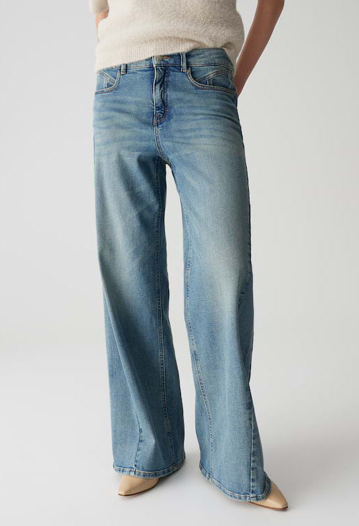 Person wearing light blue jeans on a plain background