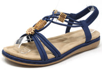 Blue sandal with wooden look beads on a white background