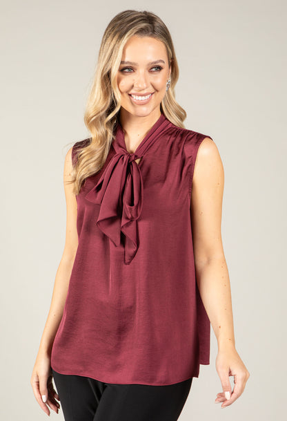 woman wearing silk feeling, sleeveless top with pussy bow detail