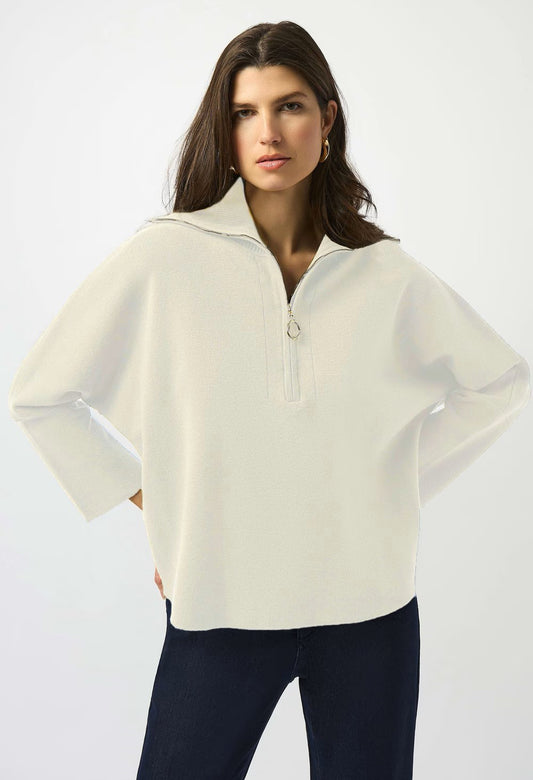 Woman wearing a green sweater and black pants on a white background