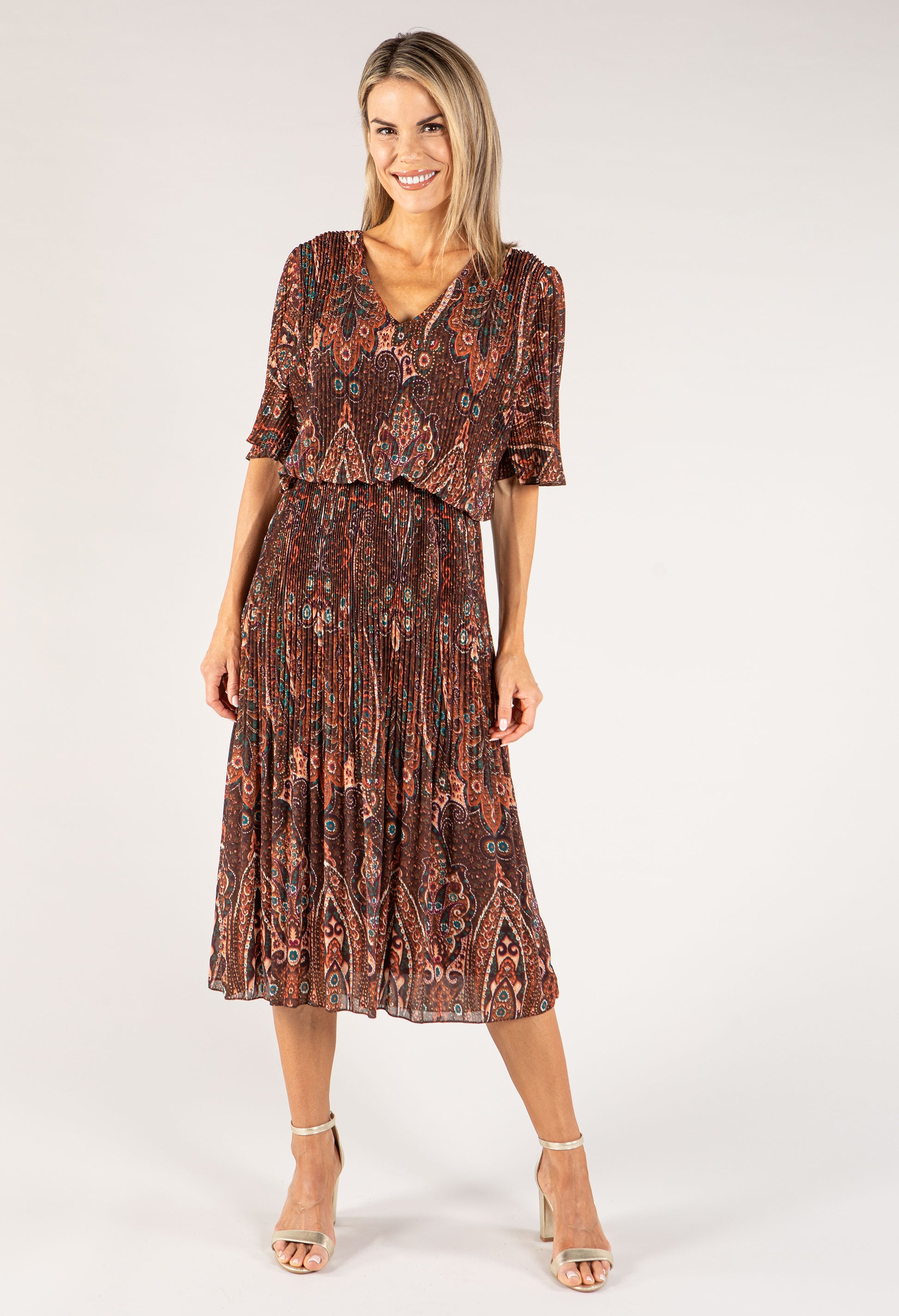 Woman wearing a patterned dress on a white background