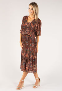 Woman wearing a patterned dress on a white background