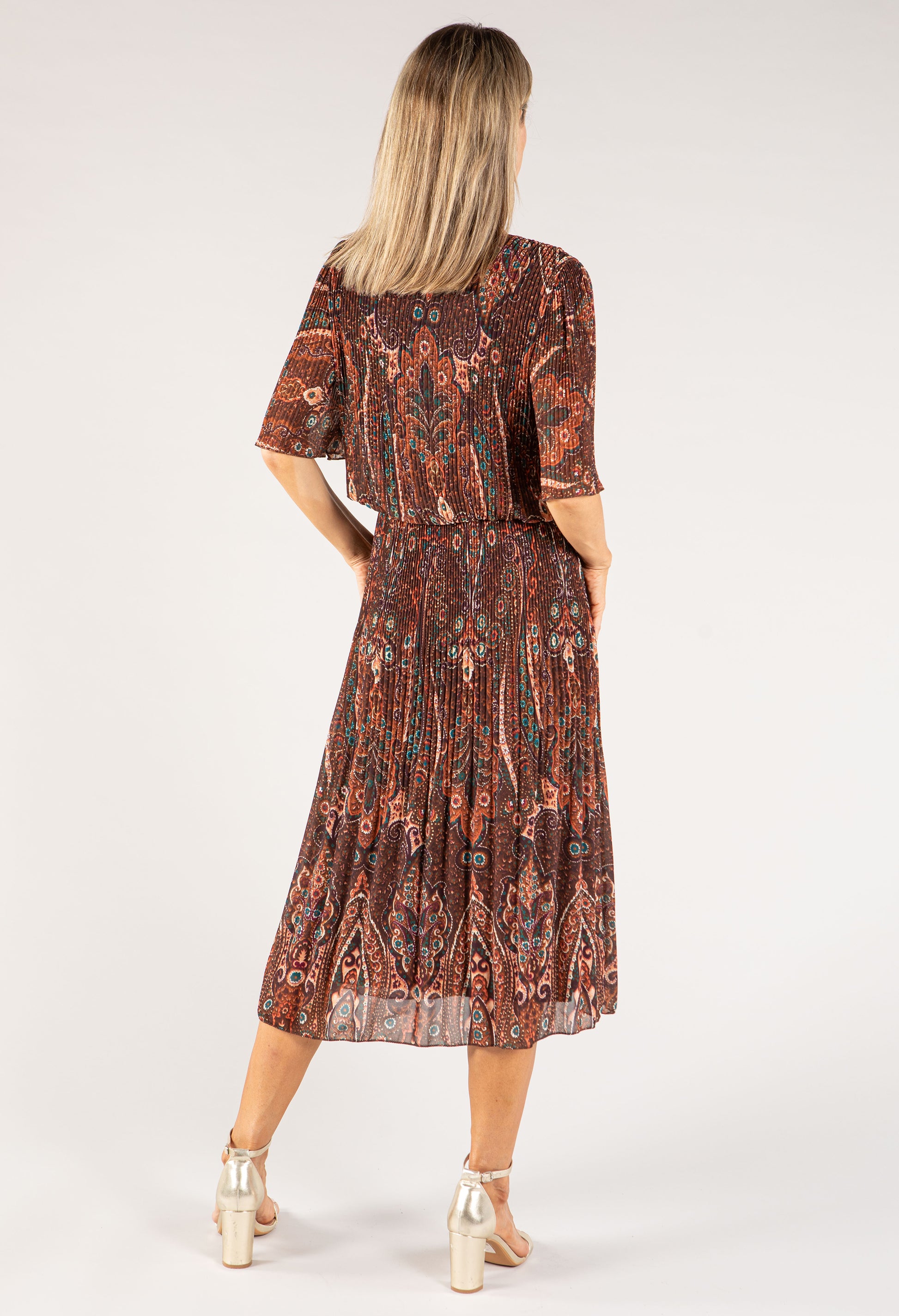 Woman wearing a patterned dress on a white background