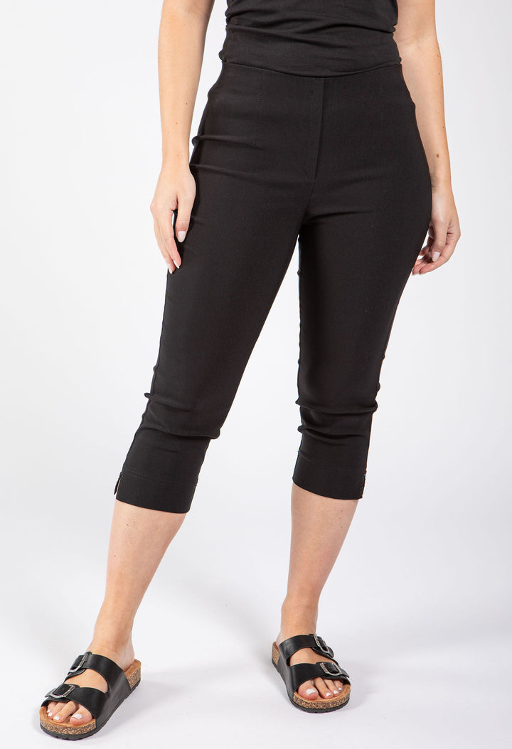 Person wearing black capri pants on a white background