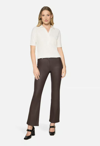 Woman wearing a white blouse and brown pants on a white background