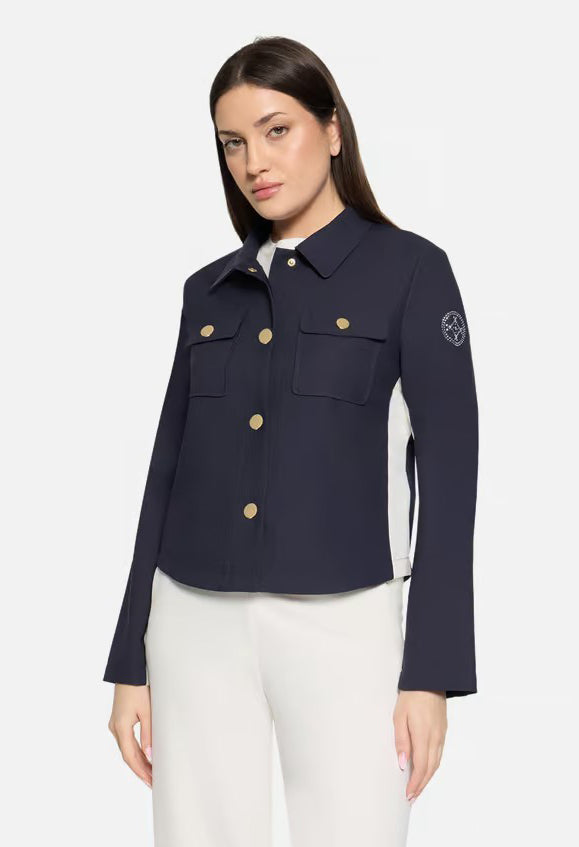 Woman wearing a navy blue jacket with gold buttons on a white background