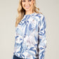 woman wearing a blue leaf patterned sweatshirt