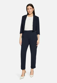 Woman wearing a navy suit with a white top on a light gray background