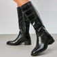 croc effect knee high boot with block heel on a grey background