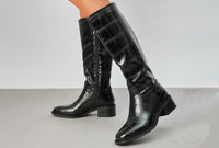 croc effect knee high boot with block heel on a grey background