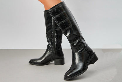 croc effect knee high boot with block heel on a grey background