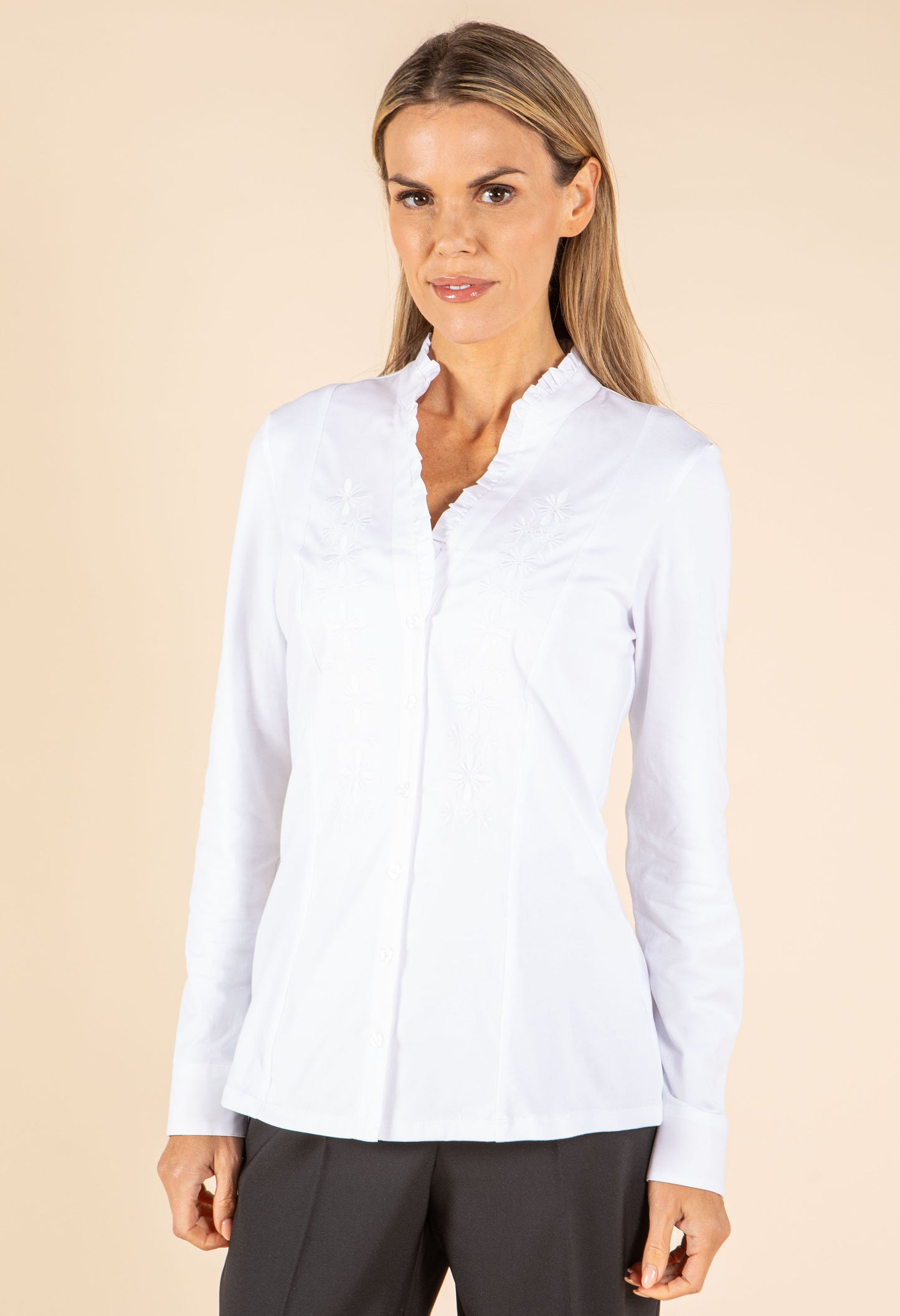 Woman wearing a white blouse against a beige background