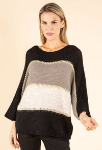 Woman wearing a black, gray, and beige striped sweater on a beige background