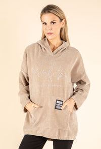Woman wearing a beige hoodie with text on a beige background