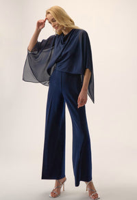 Woman wearing a navy outfit with a draped top on a white background