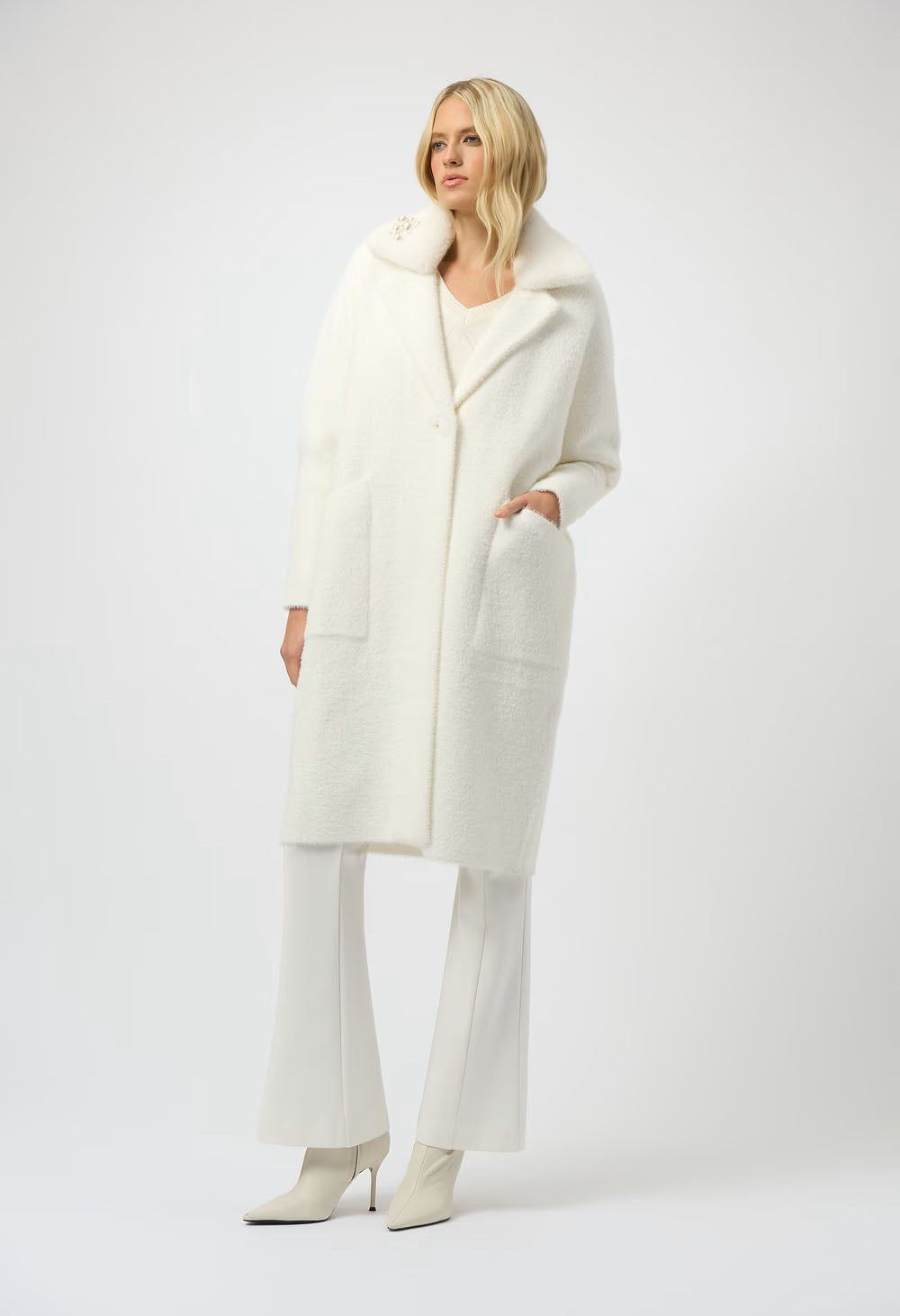 Woman wearing a white coat and pants on a white background