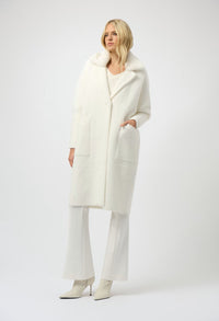 Woman wearing a white coat and pants on a white background