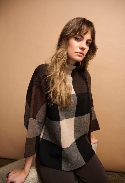Woman wearing a checkered shirt against a beige background