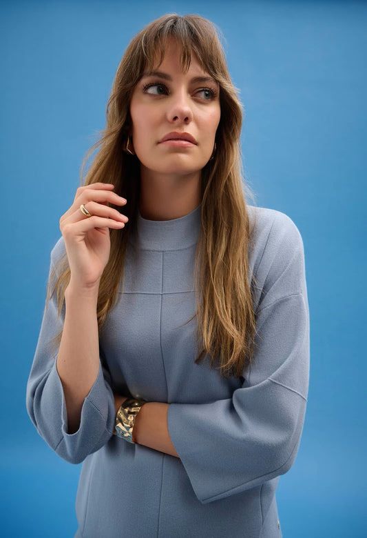 Woman wearing a white suit against a blue background