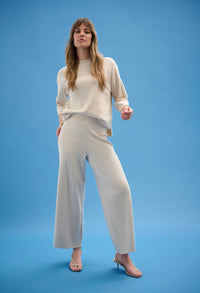 Woman wearing a white outfit on a blue background