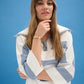 Woman wearing a white and blue striped sweater against a blue background