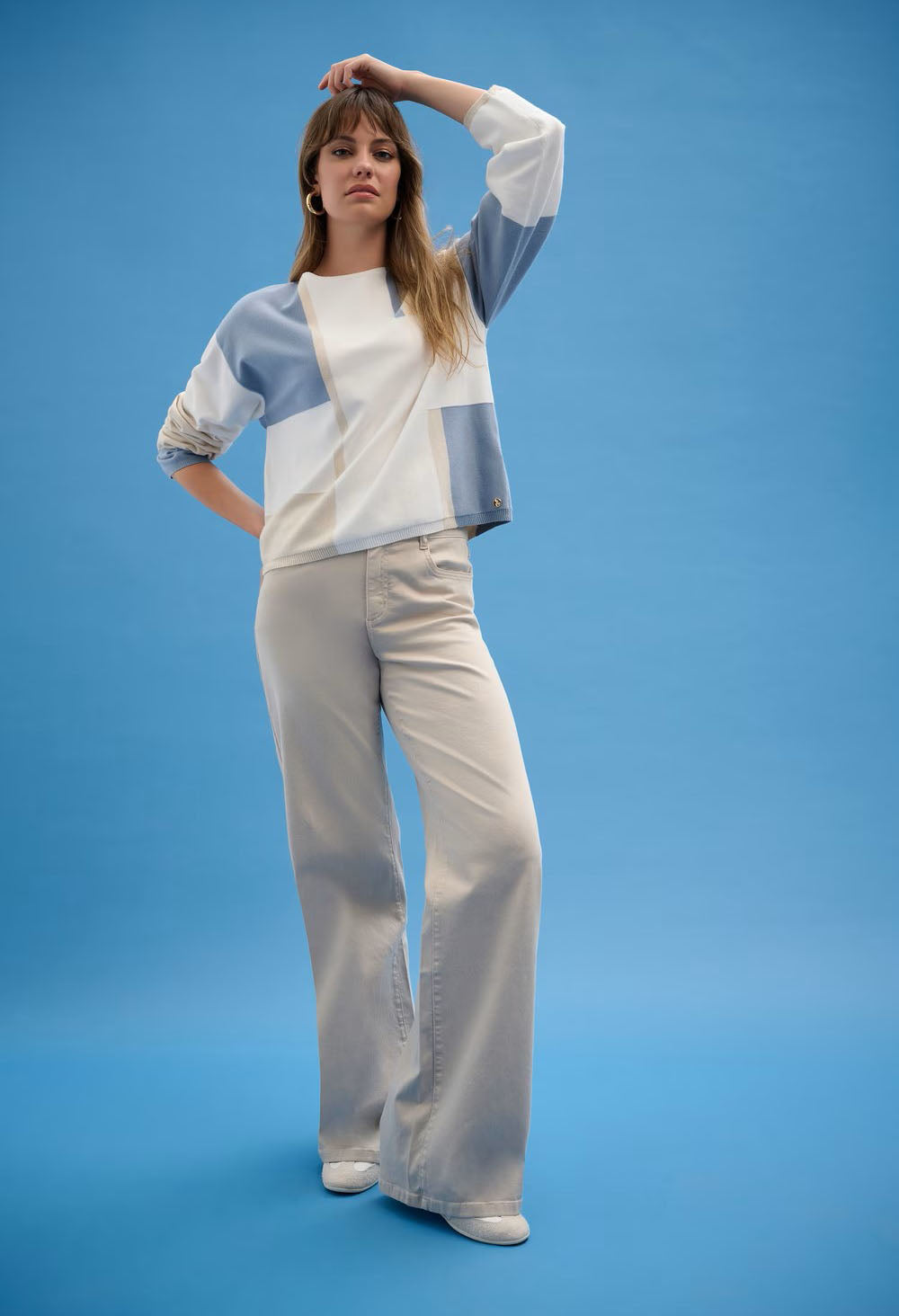 woman in geometric knit pullover on a blue background