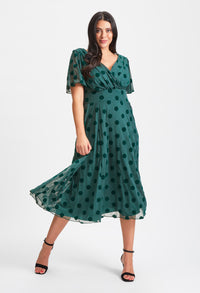 Woman wearing a green polka dot dress on a white background