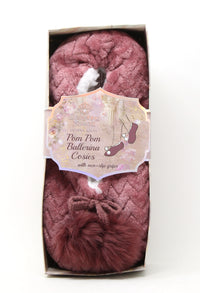 Pink pom-pom ballerina cosies in packaging with a label on a white background