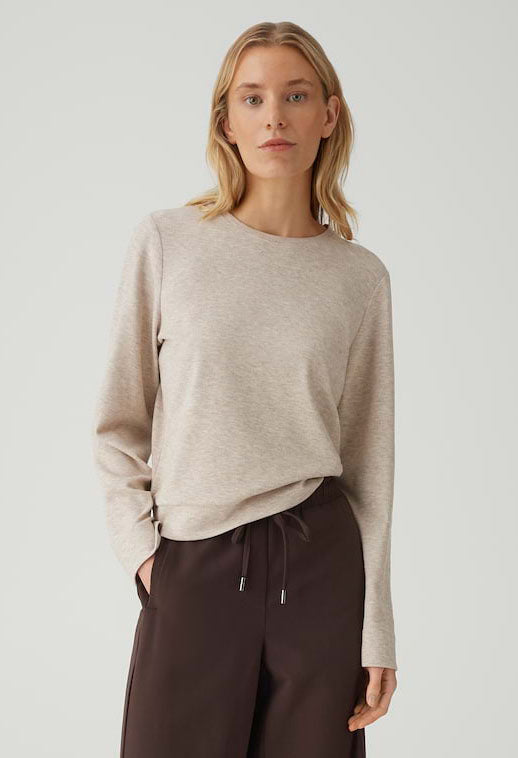 woman wearing a light beige long sleeve top