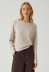 woman wearing a light beige long sleeve top