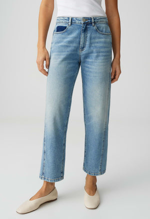 Person wearing light blue jeans on a white background