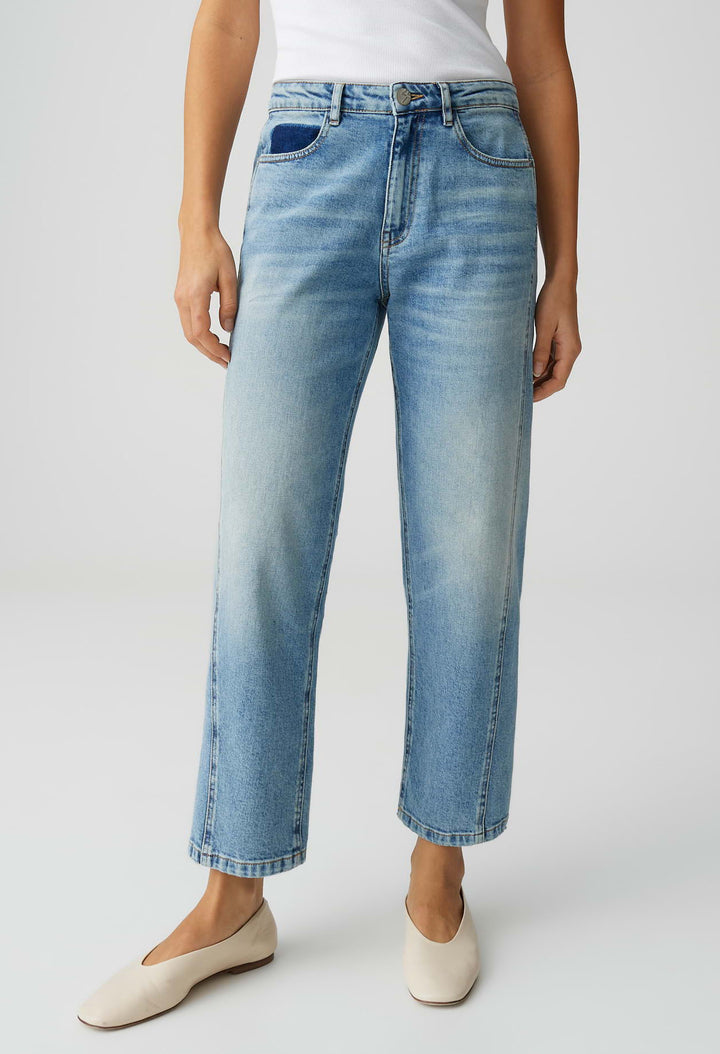 Person wearing light blue jeans on a white background