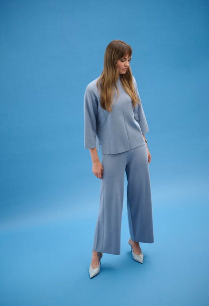 Woman wearing a light blue outfit on a blue background
