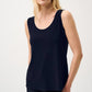 Woman wearing a navy sleeveless top against a white background