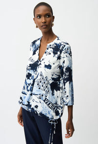 Woman wearing a blue and white patterned blouse with a plain background