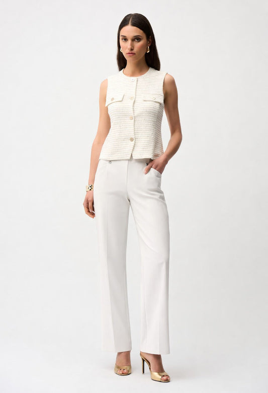 Woman wearing a white sleeveless top and beige pants on a white background