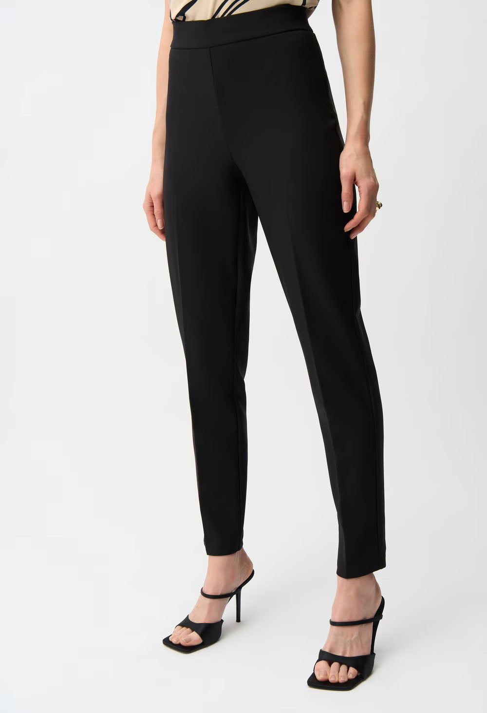 Black pants worn by a person on a white background