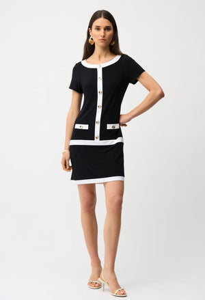 Woman wearing a black and white dress with buttons on a white background