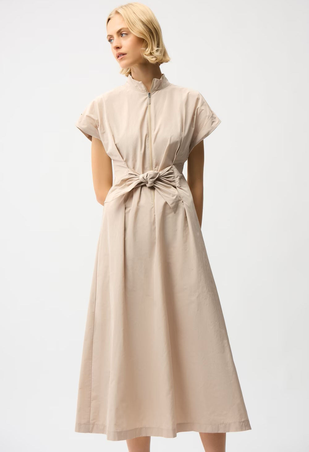 woman wearing beige wrap style dress with front zip