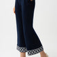 Navy blue pants with decorative hem on a white background
