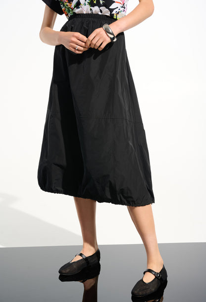 Person wearing a black skirt on a white background